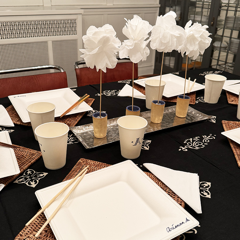 A table set with a paper flowers as the centerpiece