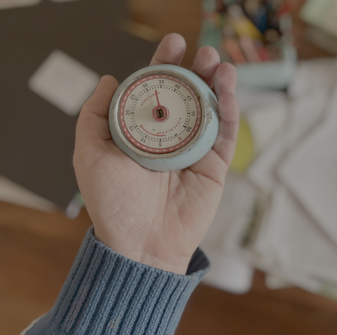 hand holding a blue timer