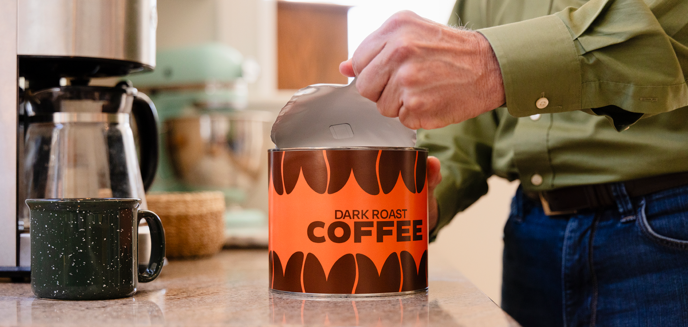 Man opening a paper can of coffee beans.