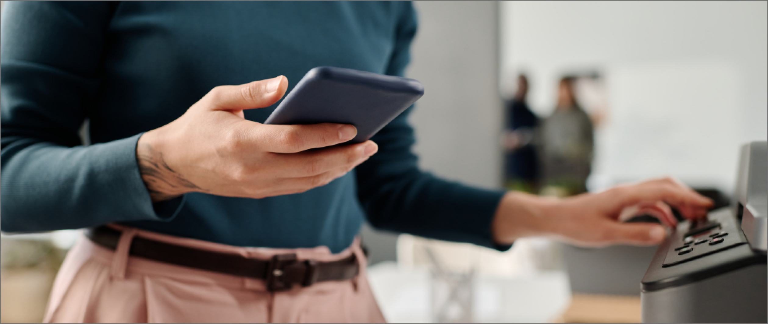 Women holding her phone in front of a printer