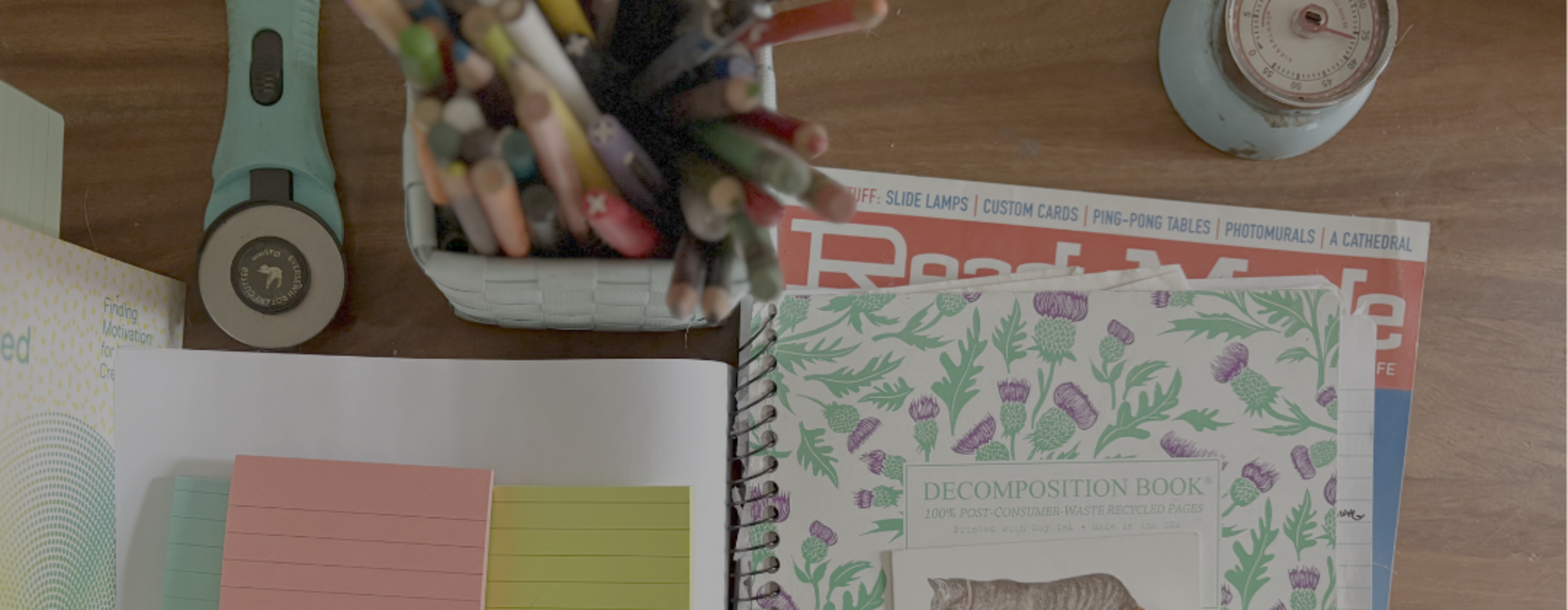 Table with notebooks, books, pens and a blue timer