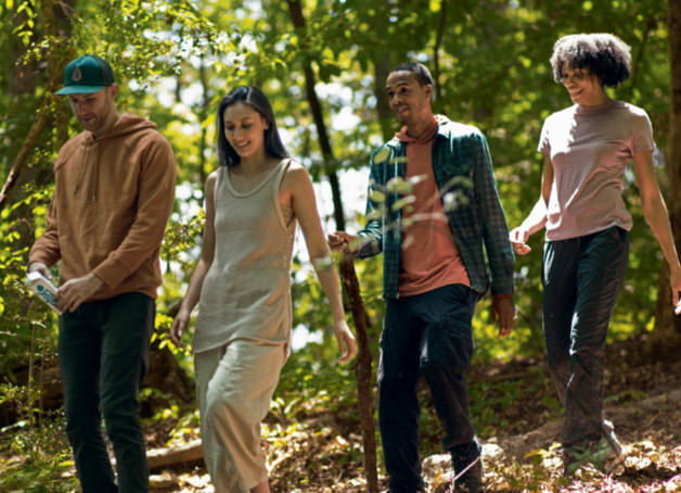 Group of 4 friends taking a hike in the shaded woods