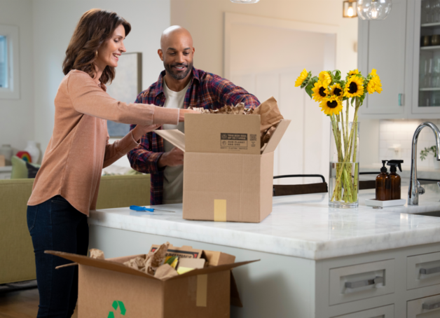 Couple opening a cardboard box and recycling it