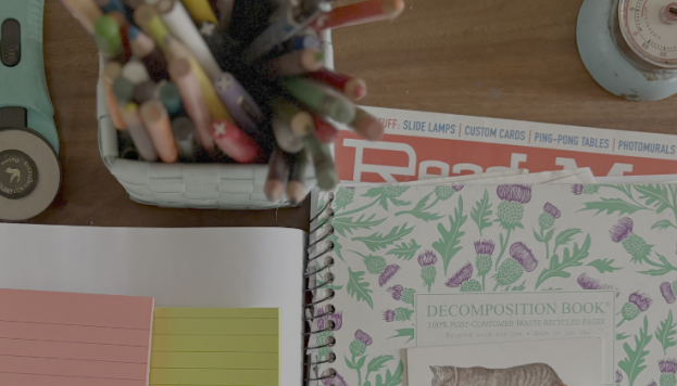 Table with notebooks, books, pens and a blue timer